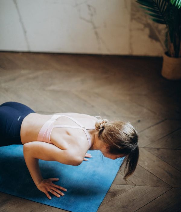Woman in a peaceful yoga pose in a light, airy room.